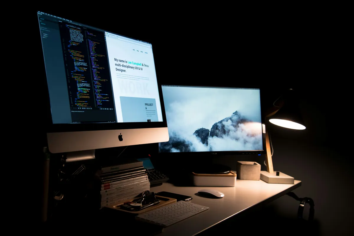 Puesto de desarrollo web con código y diseño en dos pantallas