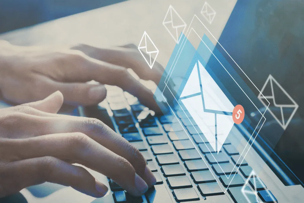 Manos escribiendo en un portátil con iconos de correo electrónico