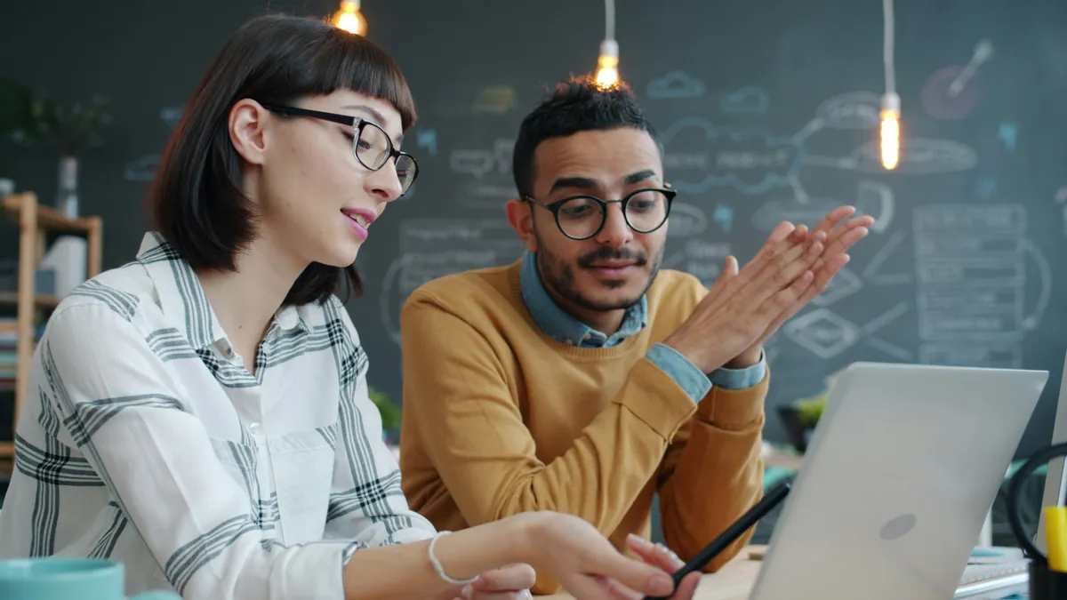 Dos profesionales analizando juntos una estrategia SEO en un ordenador