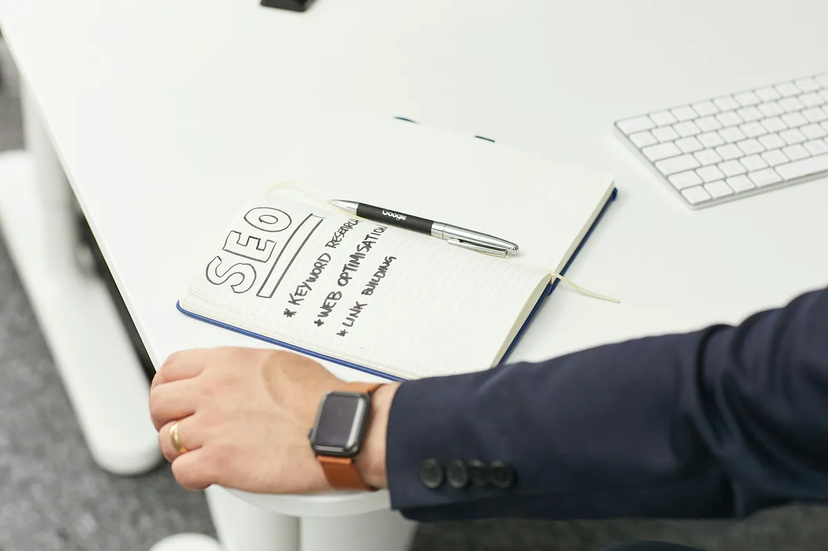 Cuaderno con notas de SEO y keyword research junto a un teclado