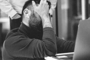 Hombre frustrado ante su portátil, reflejo de quien siente que su agencia SEO no da resultados, algo que Ventia Group ayuda a resolver
